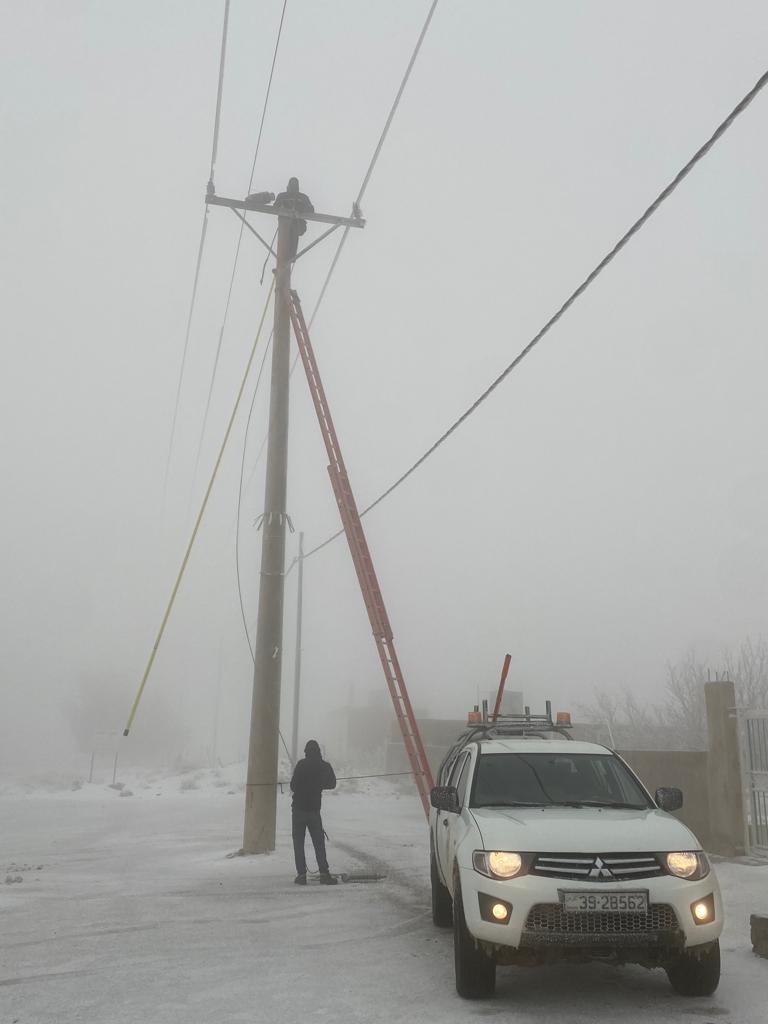 أعمال صيانة لخطوط الكهرباء من الموجة الثلجية في الأردن