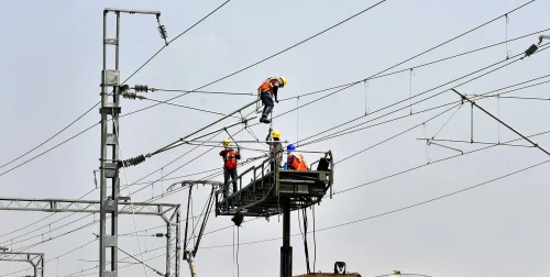 عمال يختبرون أسلاك كهربائية في الهند 