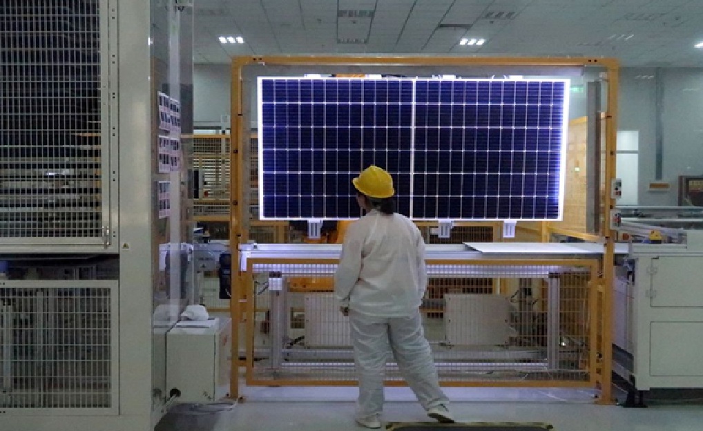 عاملة تعاين جودة ألواح الطاقة الشمسية في مصنع بمقاطعة شنشي الصينية
