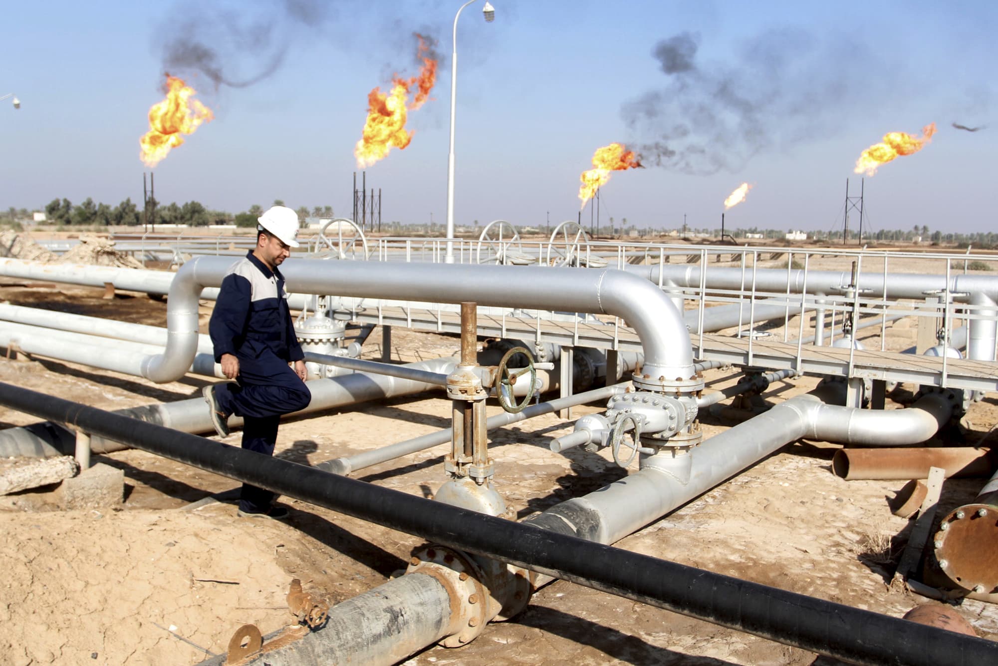 عامل يسير في حقل نهر بن عمر النفطي شمال البصرة والعراق يؤكد التزامه بقرارات أوبك+