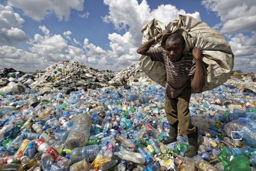 رجل يجمع النفايات البلاستيكية في مكب نفايات بأحد الأحياء الفقيرة في العاصمة الكينية نيروبي
