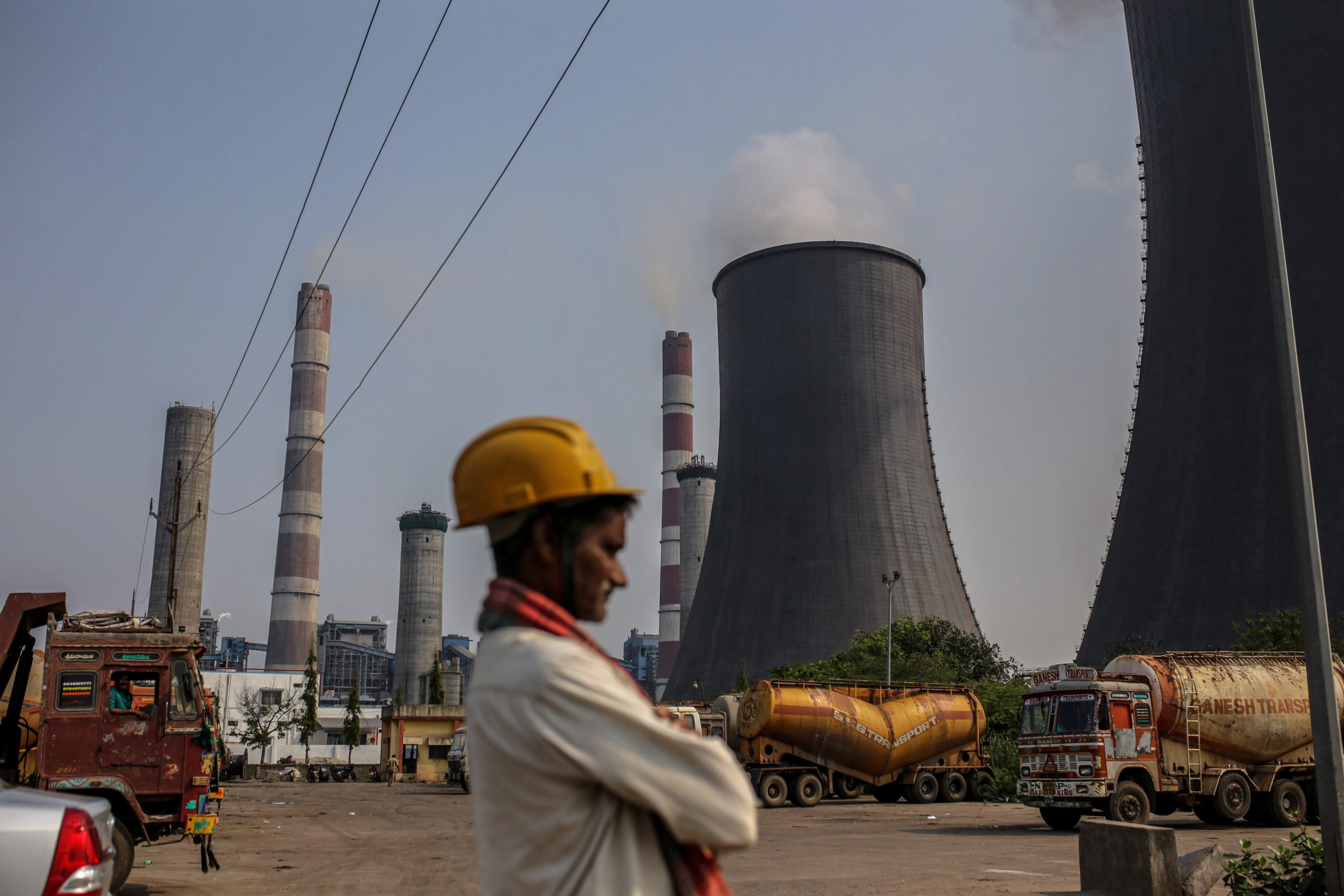 عامل يقف بجوار إحدى محطات توليد الكهرباء العاملة بالفحم في الهند- الصورة من بلومبرغ