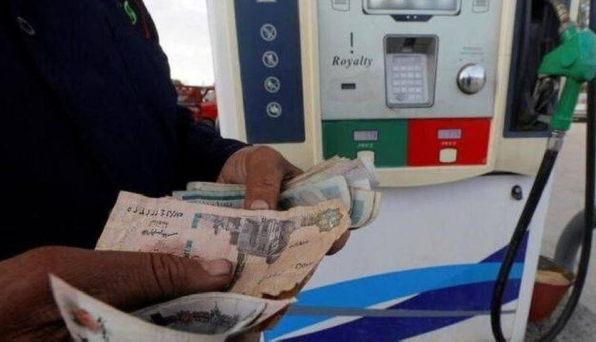 عامل يعد نقودًا في أحد محطات الوقود في مصر