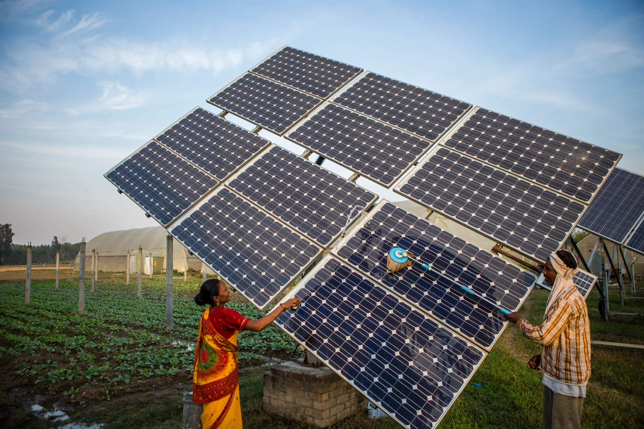 عاملان يقومان بتركيب ألواح شمسية ضمن قطاع الطاقة المتجددة في الهند