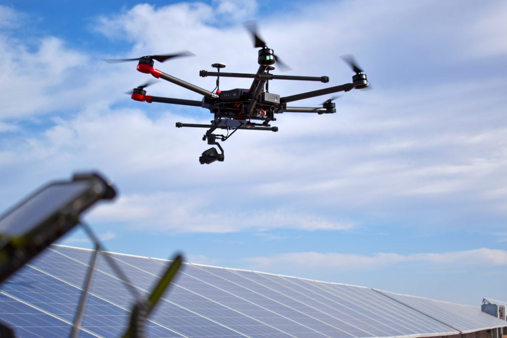 طائرة دون طيار تحلق بجوار ألواح الطاقة الشمسية على الأسطح