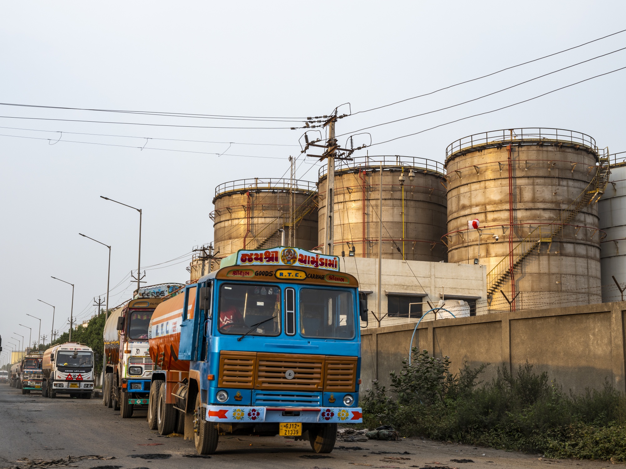 شاحنات تقف أمام خزانات نفطية في الهند