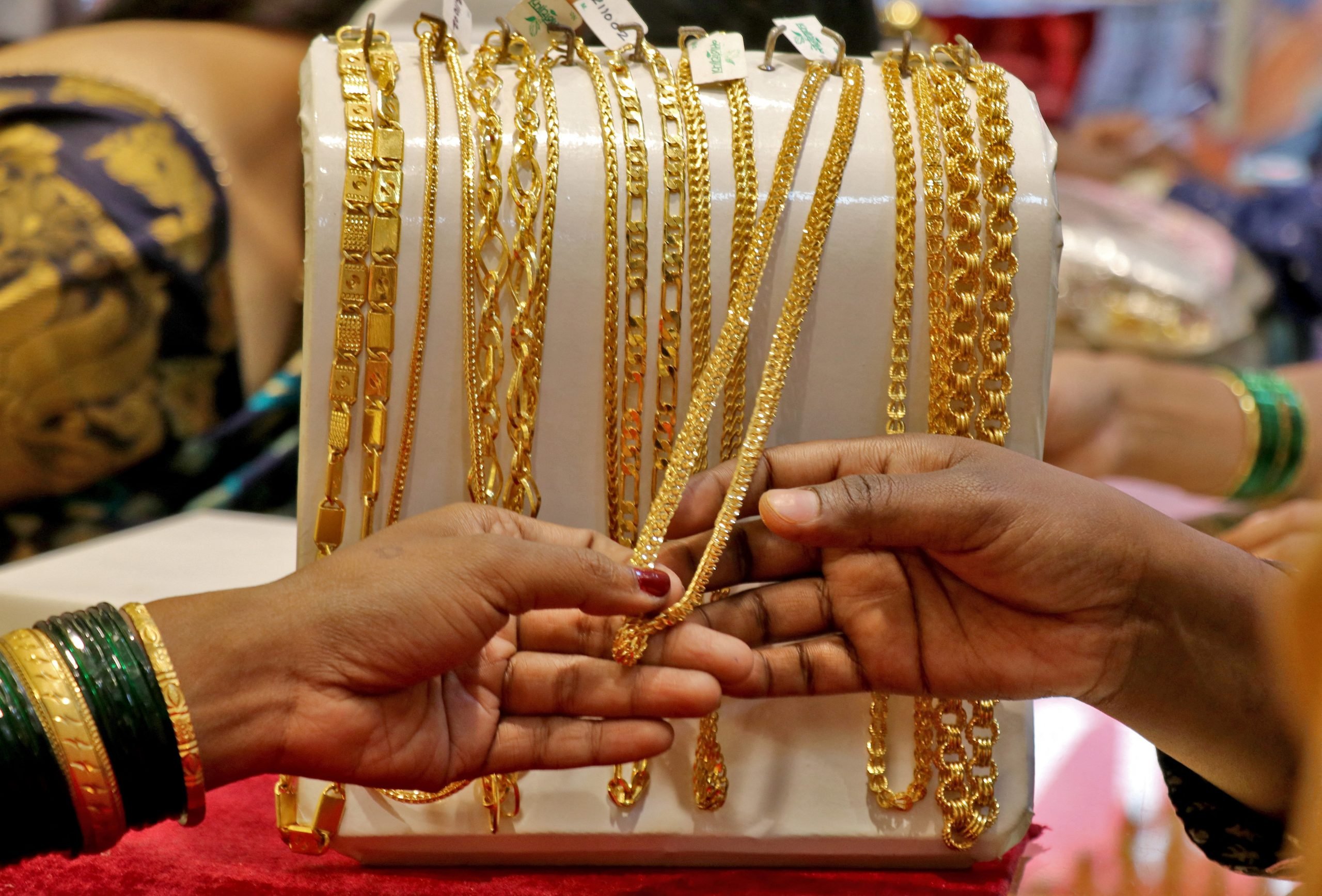 عملاء يتفقّدون مشغولات ذهبية بأحد المعارض في الهند