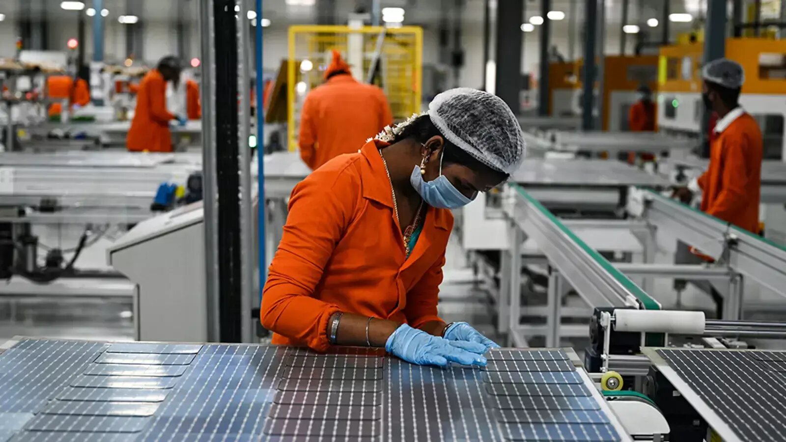 عاملة في مصنع لإنتاج الألواج الشمسية