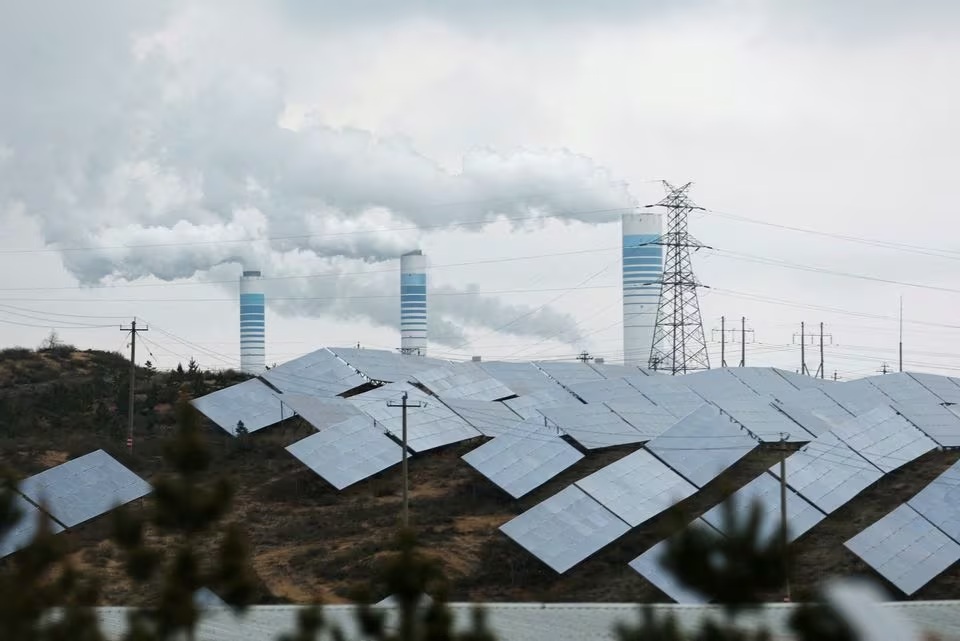 محطة لتوليد الكهرباء بالفحم قرب ألواح شمسية في إحدى المقاطعات الصينية