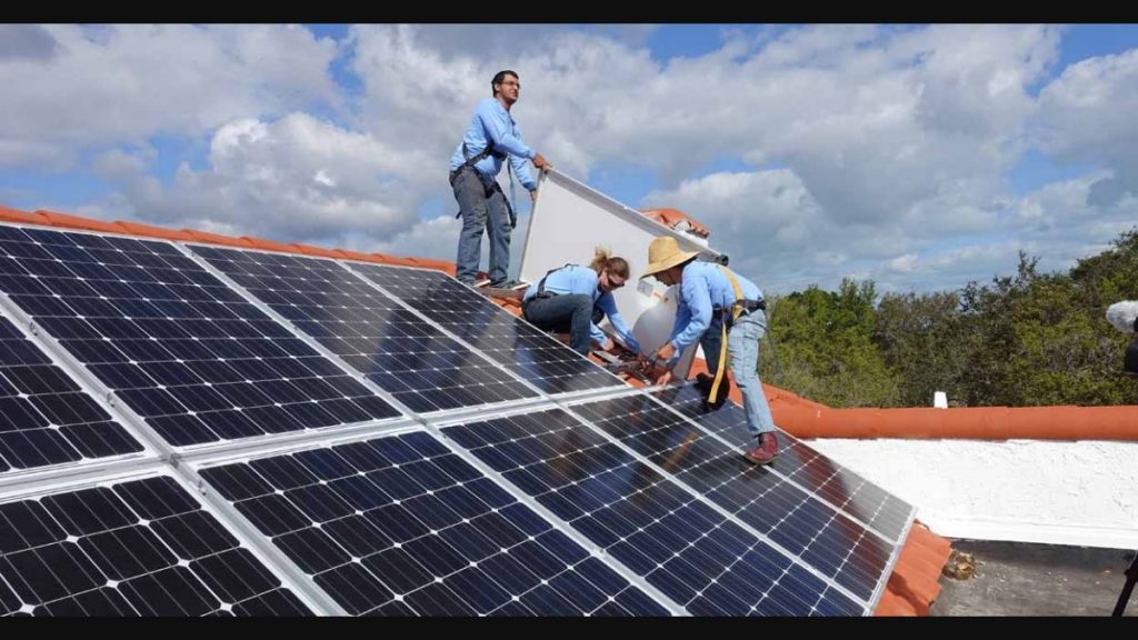 عمال أثناء تركيب ألواح شمسية على الأسطح