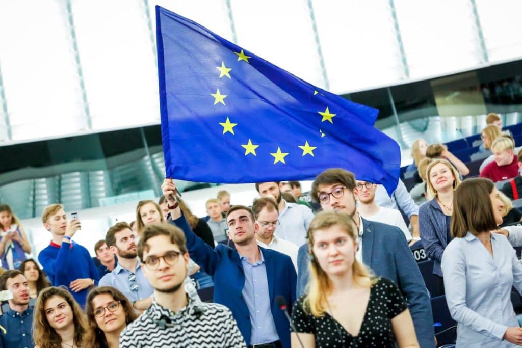 شاب يرفع علم الاتحاد الأوروبي