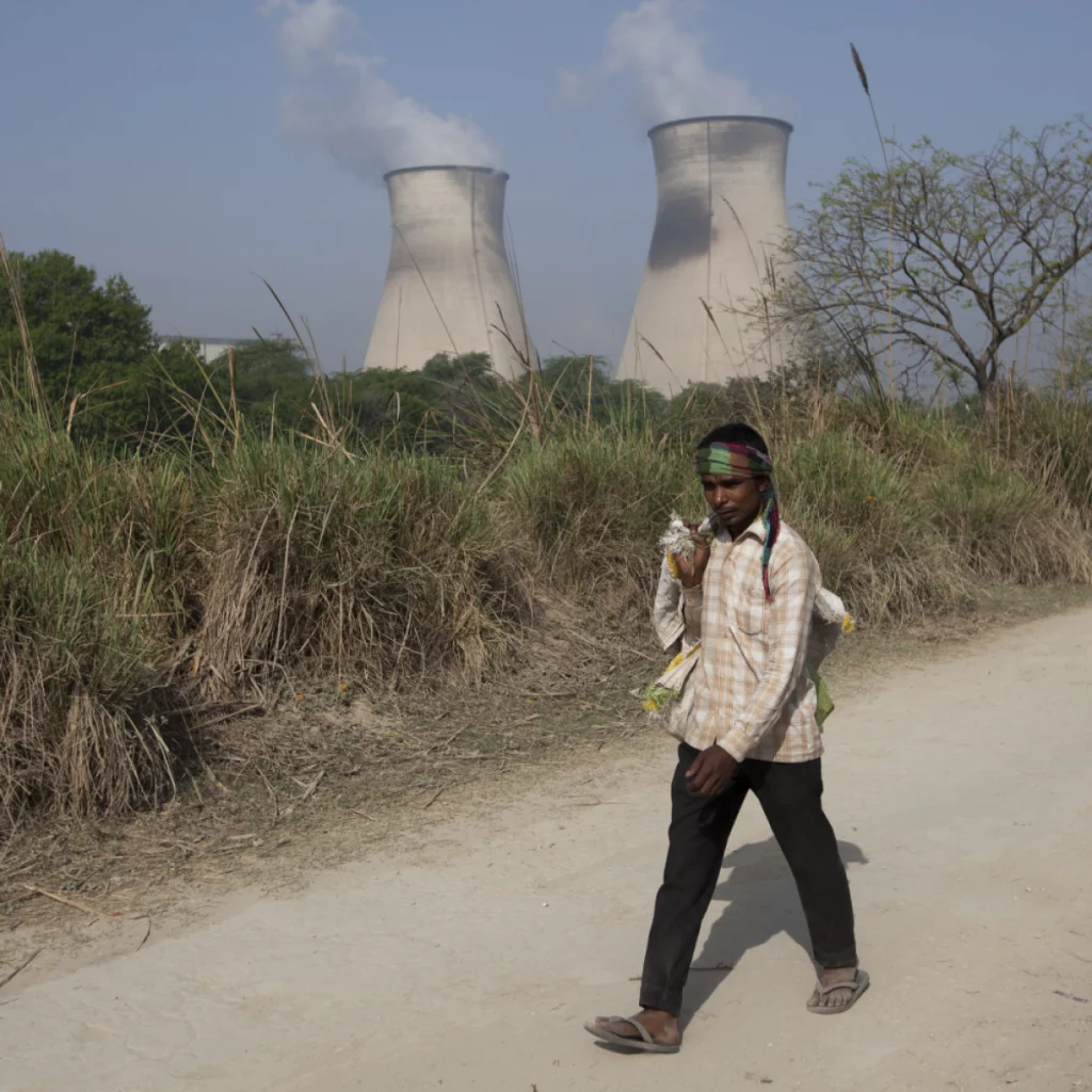 شاب وفي الخلفية أبراج محطة نووية بالهند 
