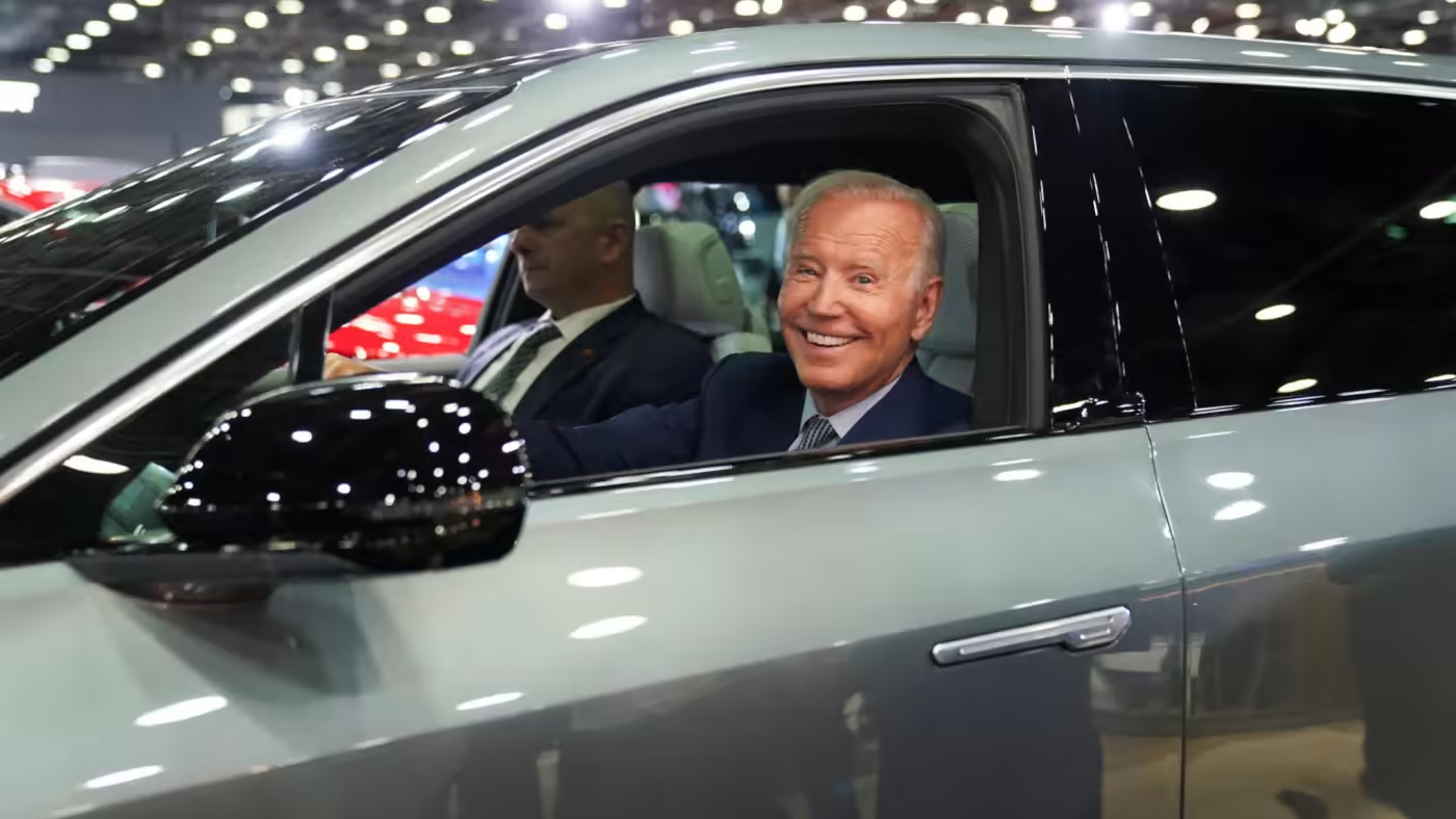 الرئيس الأميركي جو بايدن يقود سيارة كهربائية