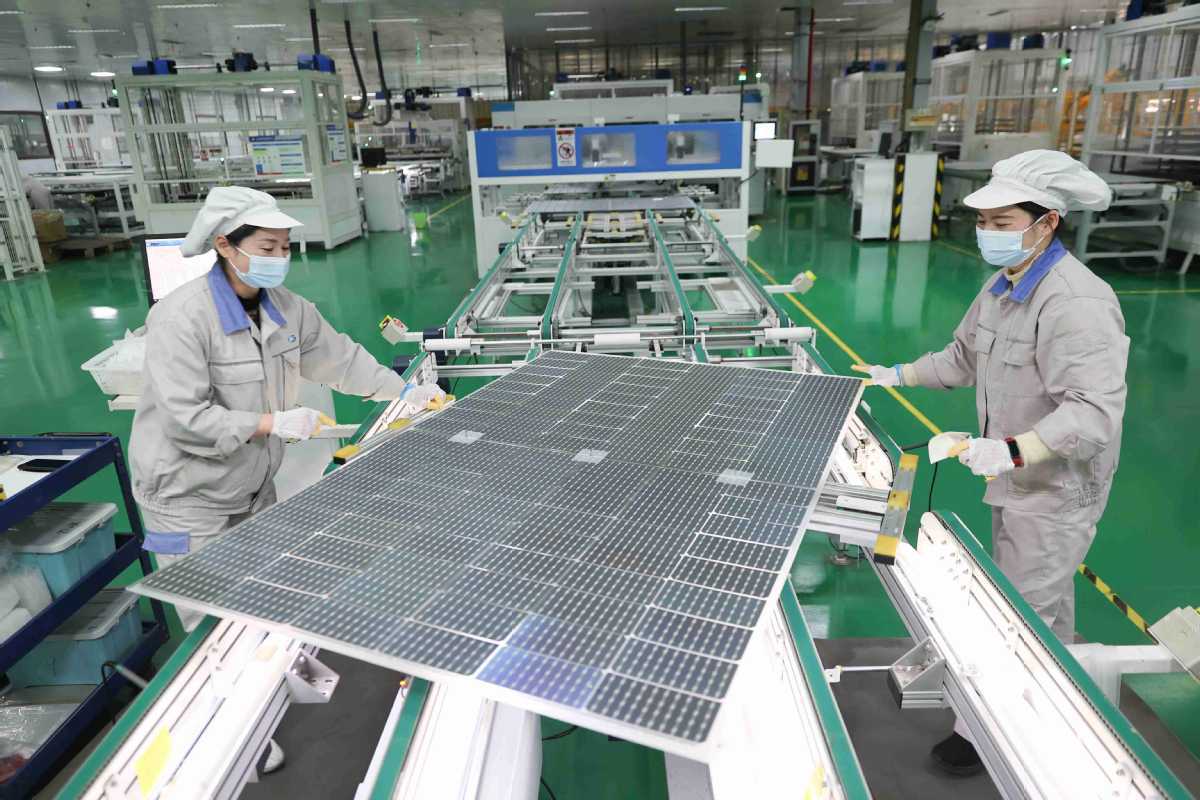 عاملتان داخل مصنع لإنتاج الألواح الشمسية في الصين
