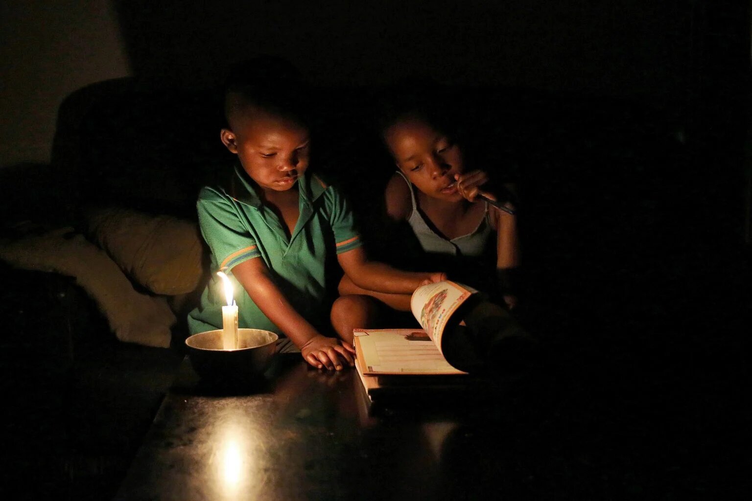 طفلان في الظلام أثناء انقطاع الكهرباء في جنوب أفريقيا