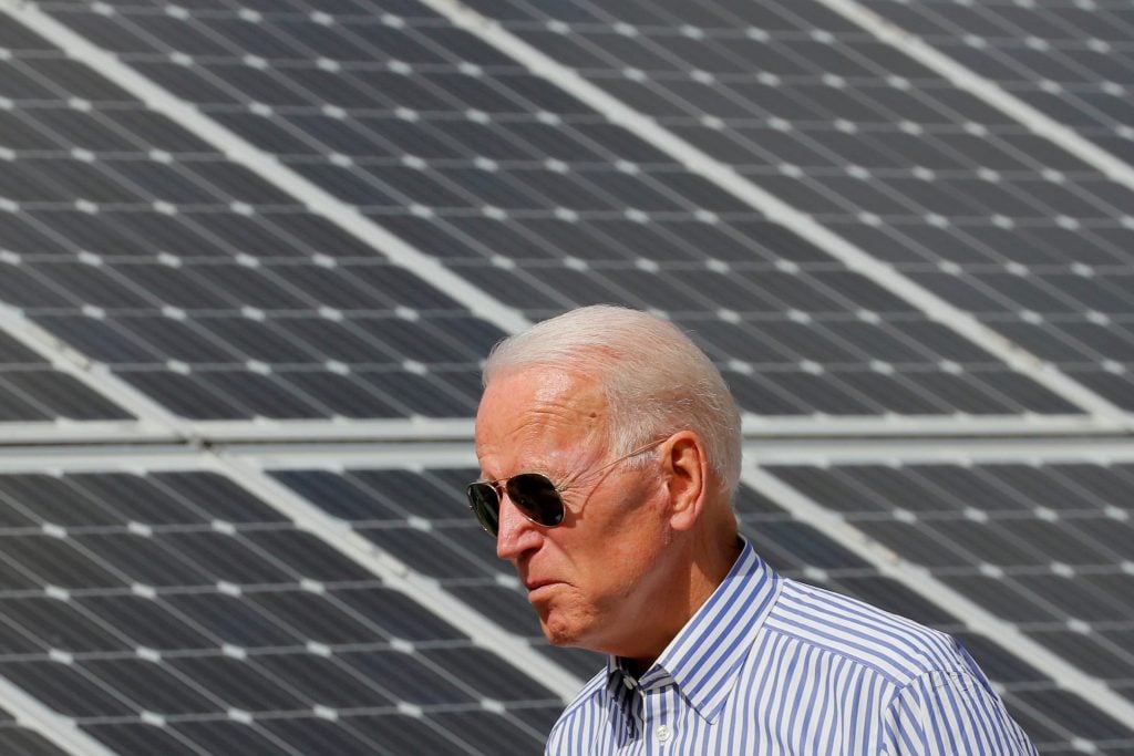 الرئيس جو بايدن وفي الخلفية ألواح شمسية