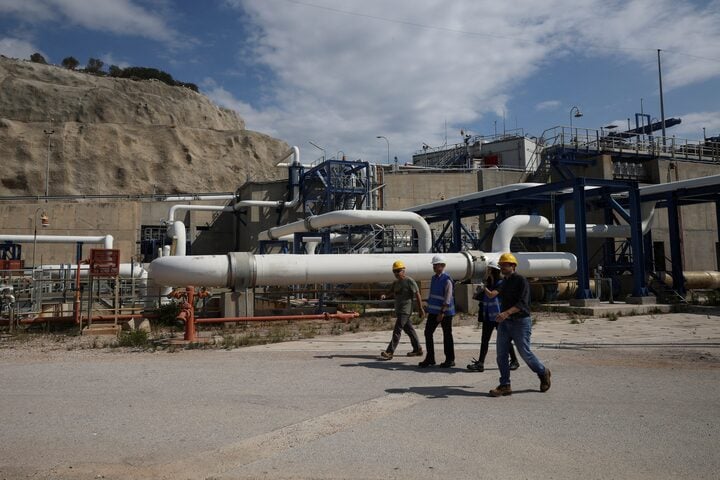 عمال أمام خطوط أنابيب داخل محطة ريفيثوسا لاستيراد الغاز المسال