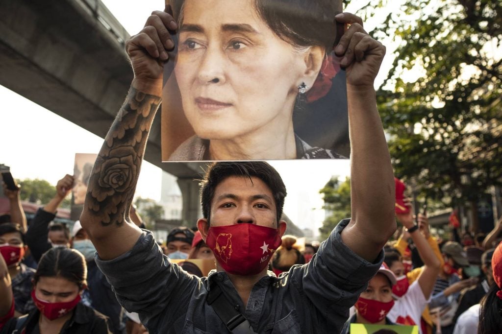 متظاهر يحمل صورة مستشارة ماينمار أونغ سان سوتشي المسجونة بعد الانقلاب العسكري