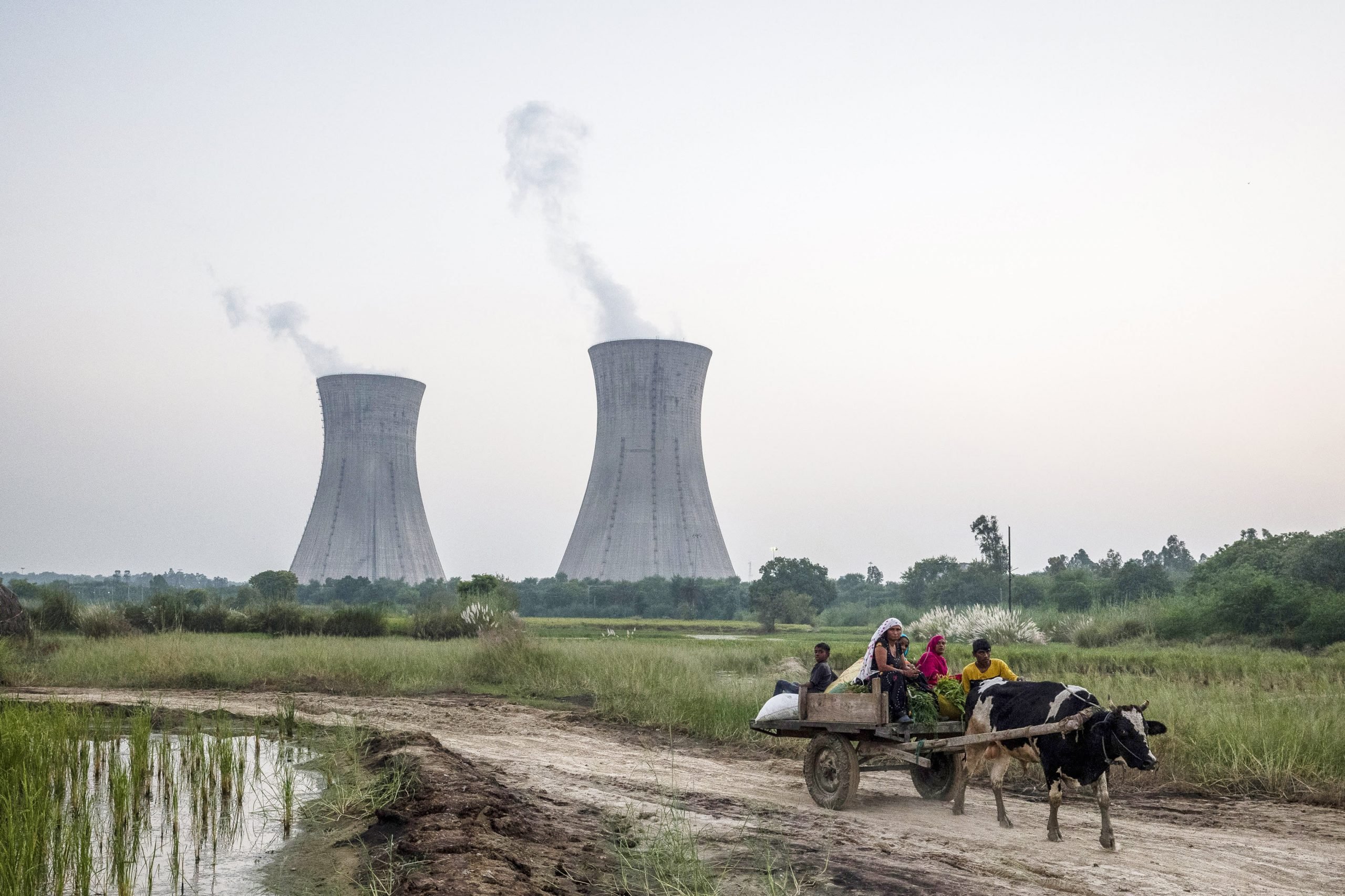 مواطنان أمام محطة لتوليد الكهرباء من الفحم في الهند