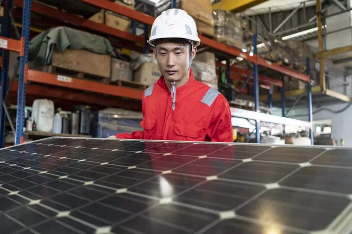 عامل يُجهّز وحدة شمسية في مصنع بالصين
