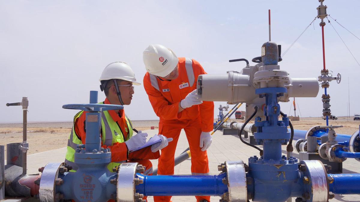مهندسان في أثناء اختبار أنبوب لنقل الهيدروجين
