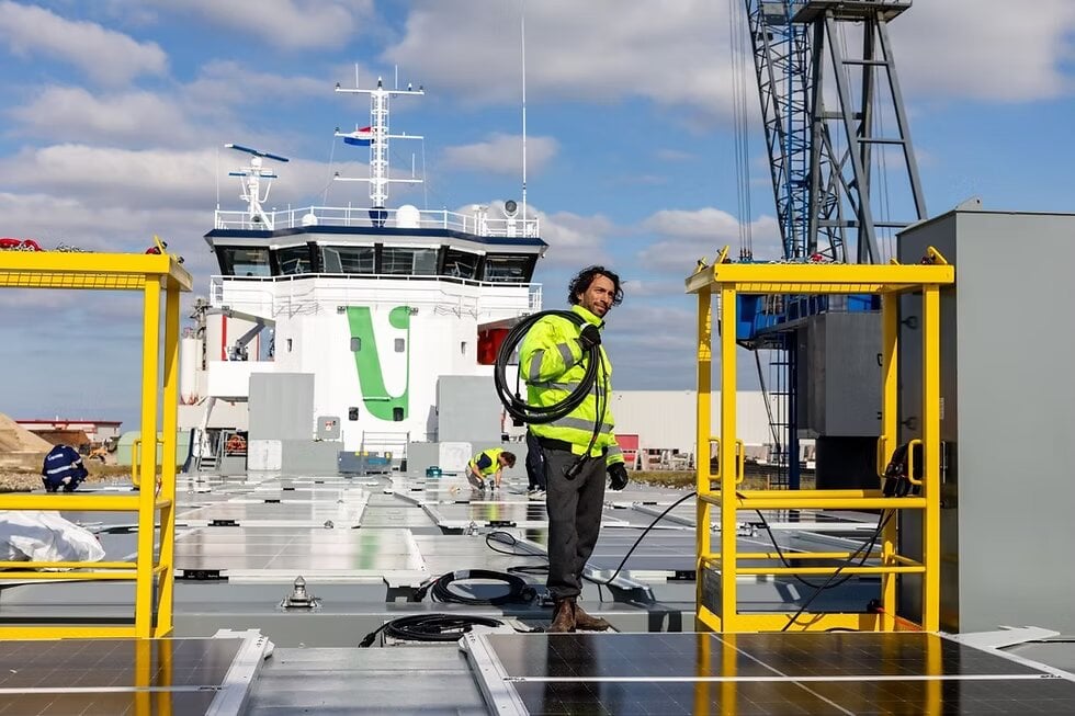 عامل يشارك في تركيب ألواح شمسية على السفينة