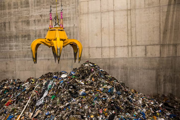 مخلب ميكانيكي يجمع النفايات في محطة لتحويل النفايات إلى كهرباء