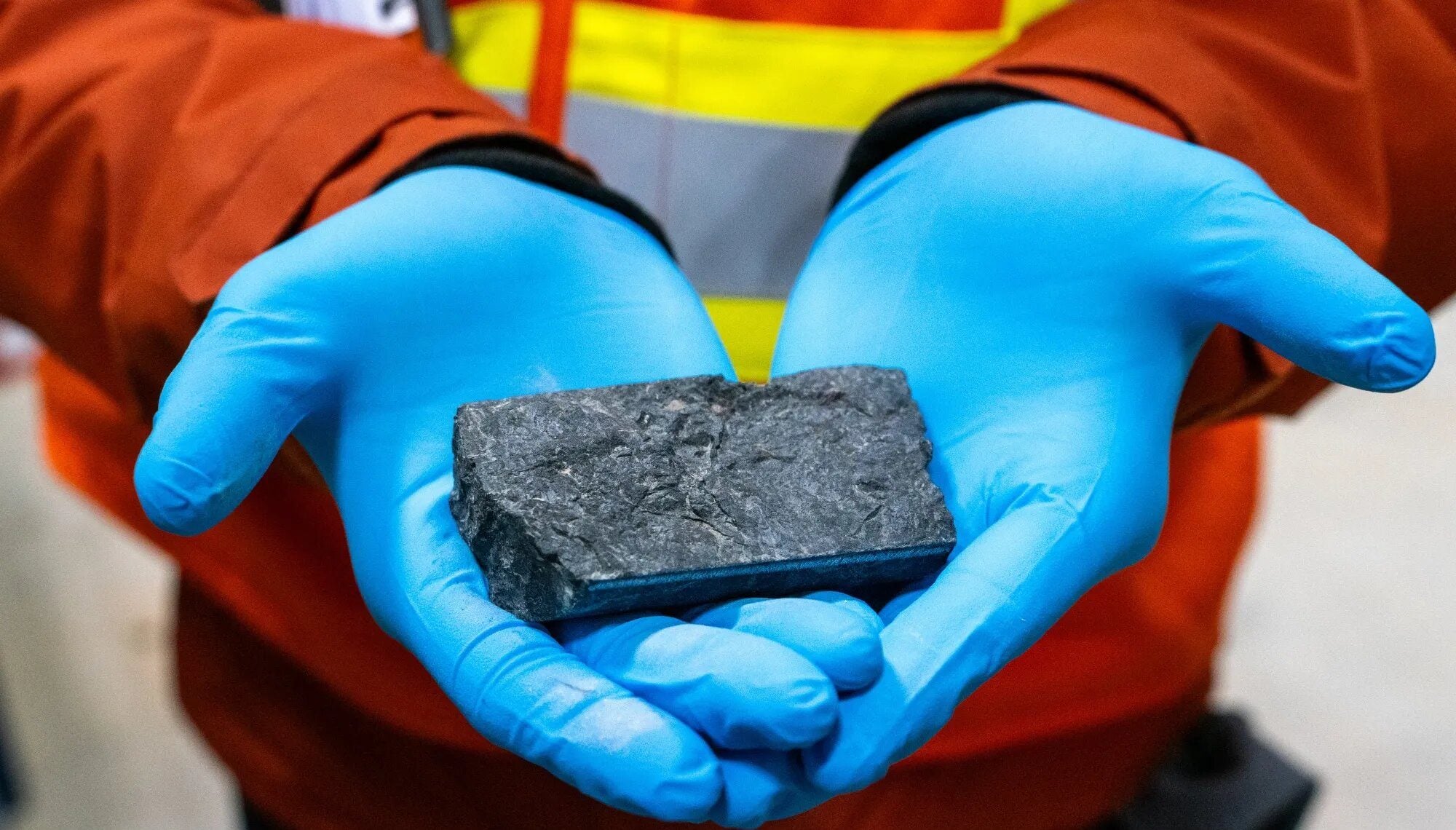 شخص يمسك عينة من معدن اليورانيوم