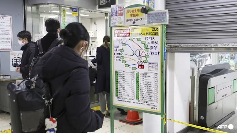 راكب يتابع حركة القطارات بعد انقطاع الكهرباء عن السكك الحديدية في اليابان