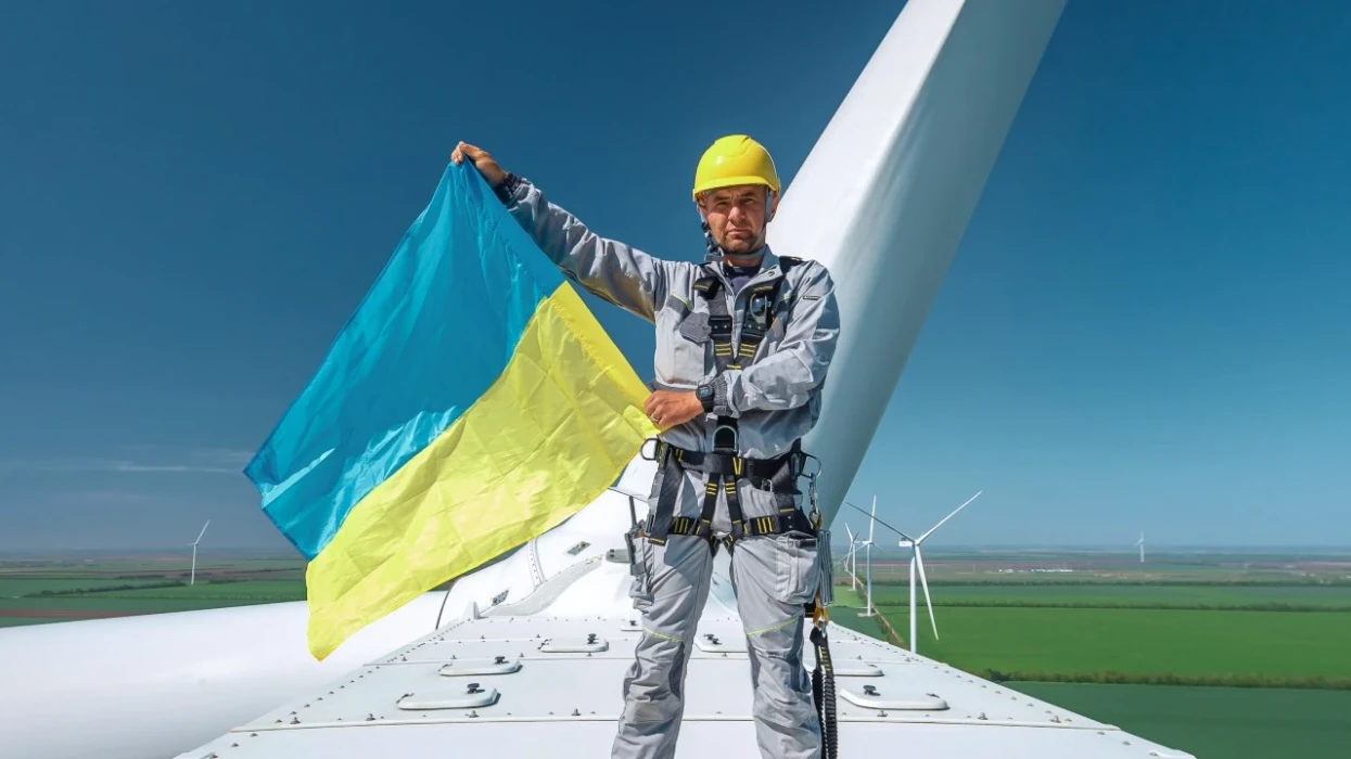 فني يقف على قيمة أحد توربينات الرياح في مزرعة رياح تيليغولسكا