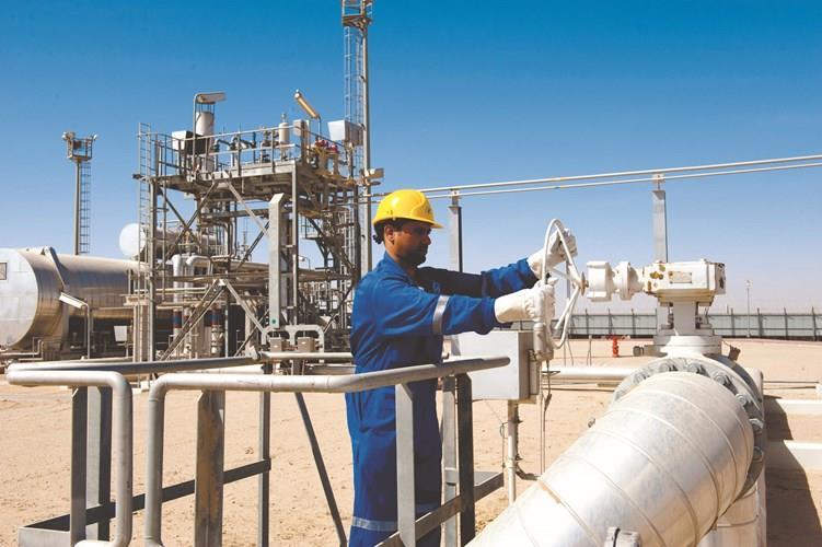 عامل يتابع خطوط أنابيب النفط في الكويت