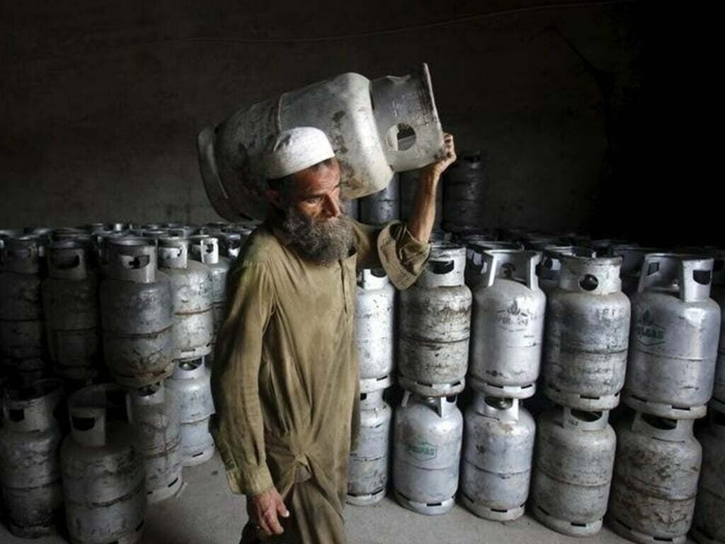 شخص باكستاني يحمل أسطوانة غاز نفط مسال